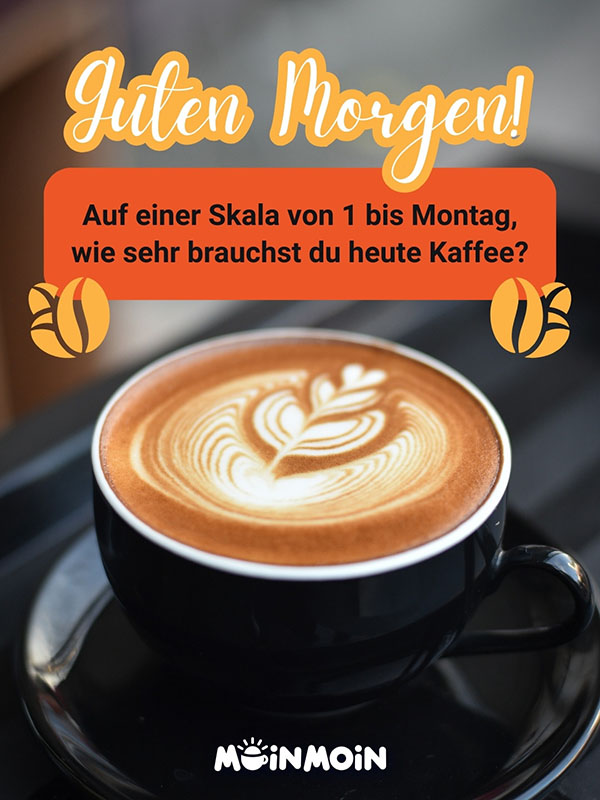 Cappuccino in einer schwarzen Tasse mit Guten Morgen Montag Gruß: „Guten Morgen! Auf einer Skala von 1 bis Montag, wie sehr brauchst du heute Kaffee?”