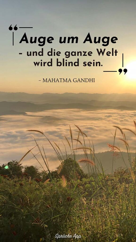 Bergspitze über den Wolken mit Zitat: „Auge um Auge - und die ganze Welt wird blind sein.“ von Mahatma Gandhi