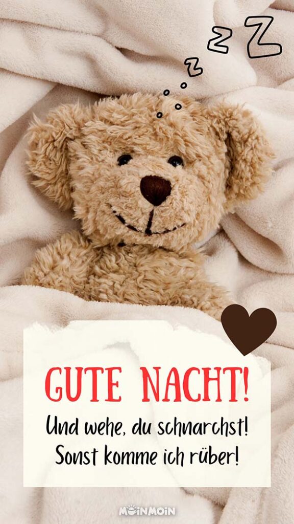 Teddybär, der im Bett liegt mit lustigen Grüßen: „Gute Nacht! Und wehe, du schnarchst! Sonst komme ich rüber!“